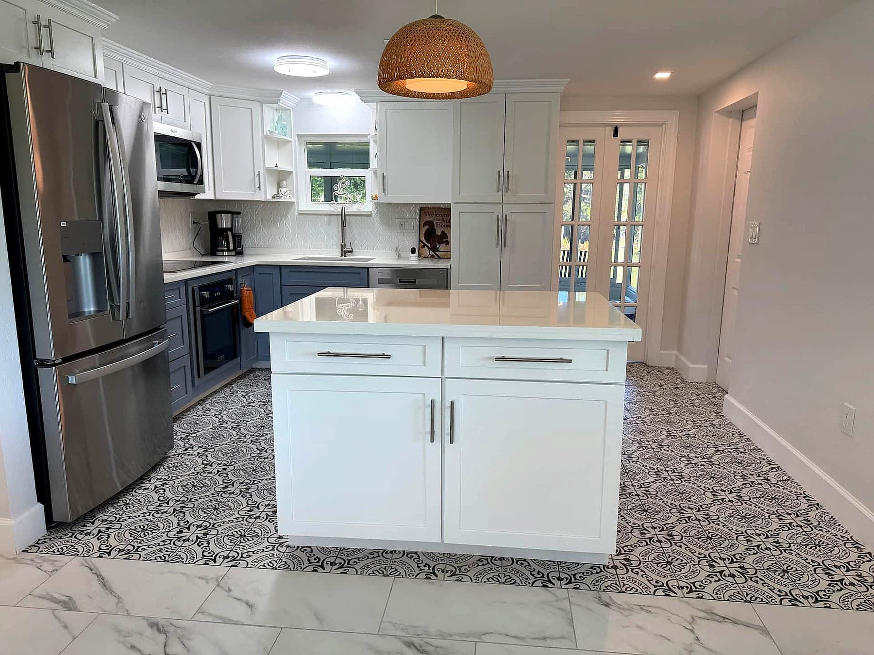 The remodeled kitchen at Your Sanctuary, with a white island and patterned tile floor